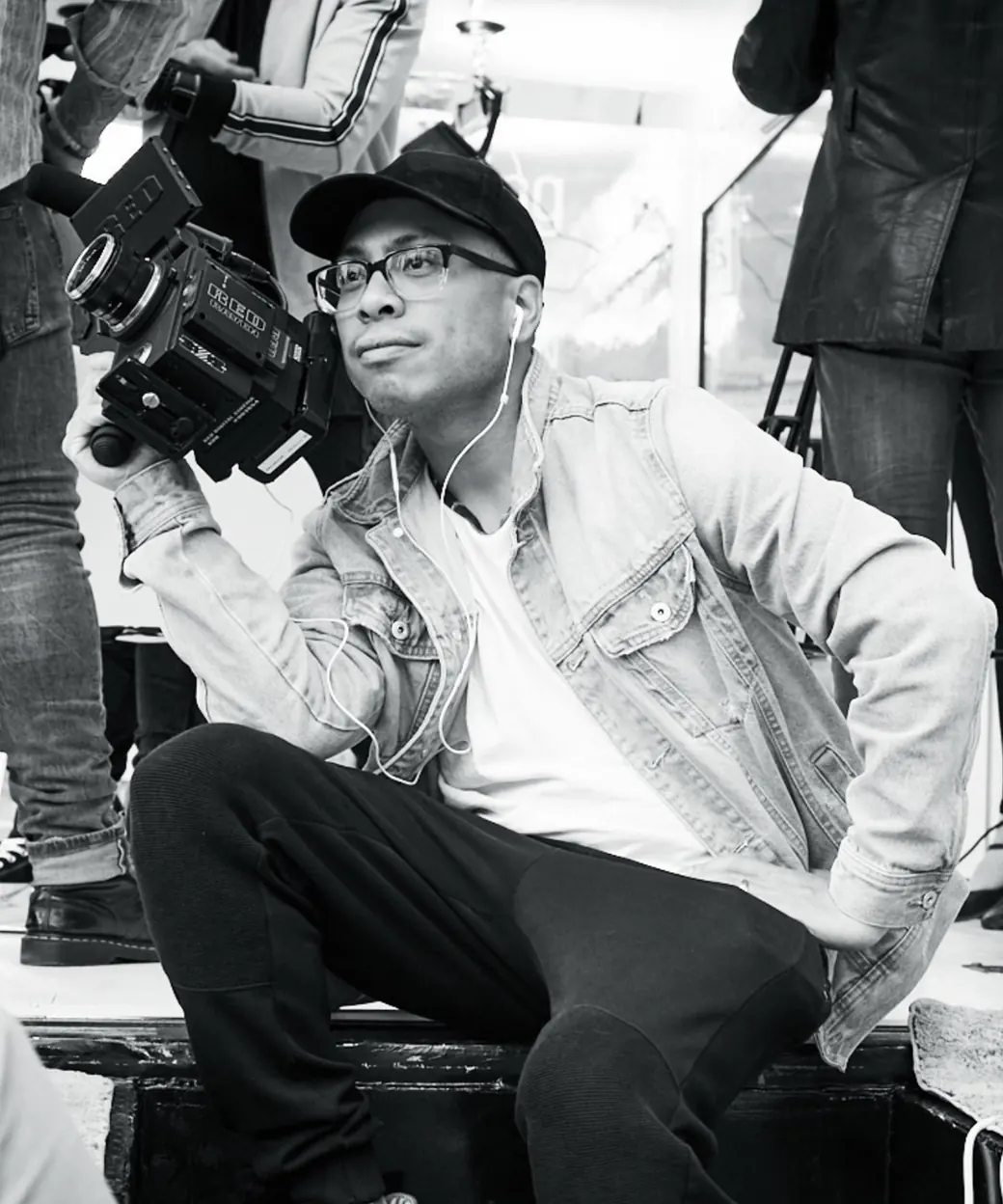 Chris Dela Cruz on set with a RED camera on his shoulder